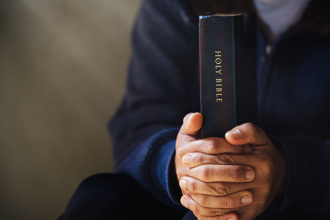 Hand Tightly Holding the Bible 