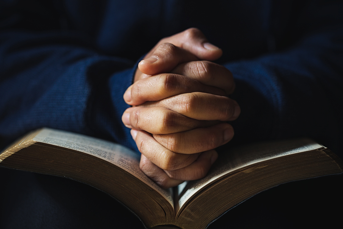 Hands Folded in Prayer on a Holy Bible 