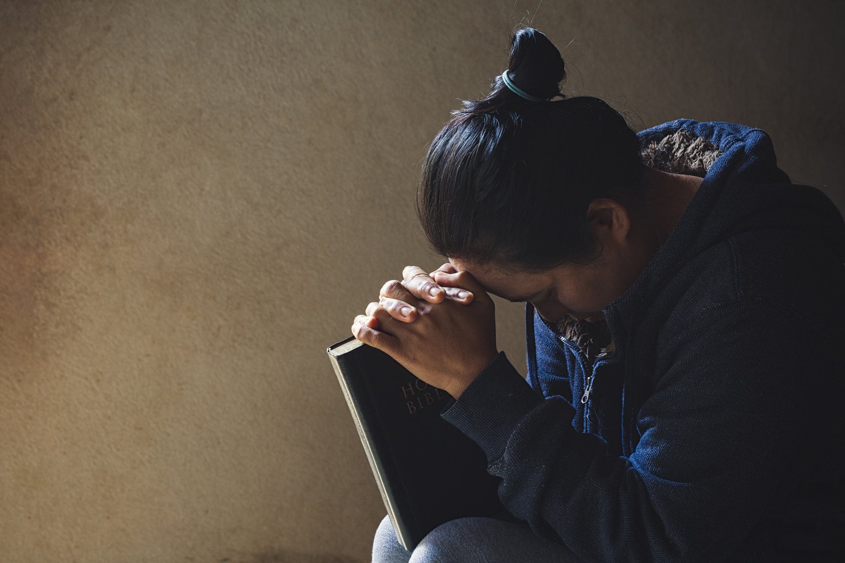 Hands Folded in Prayer on a Holy Bible 